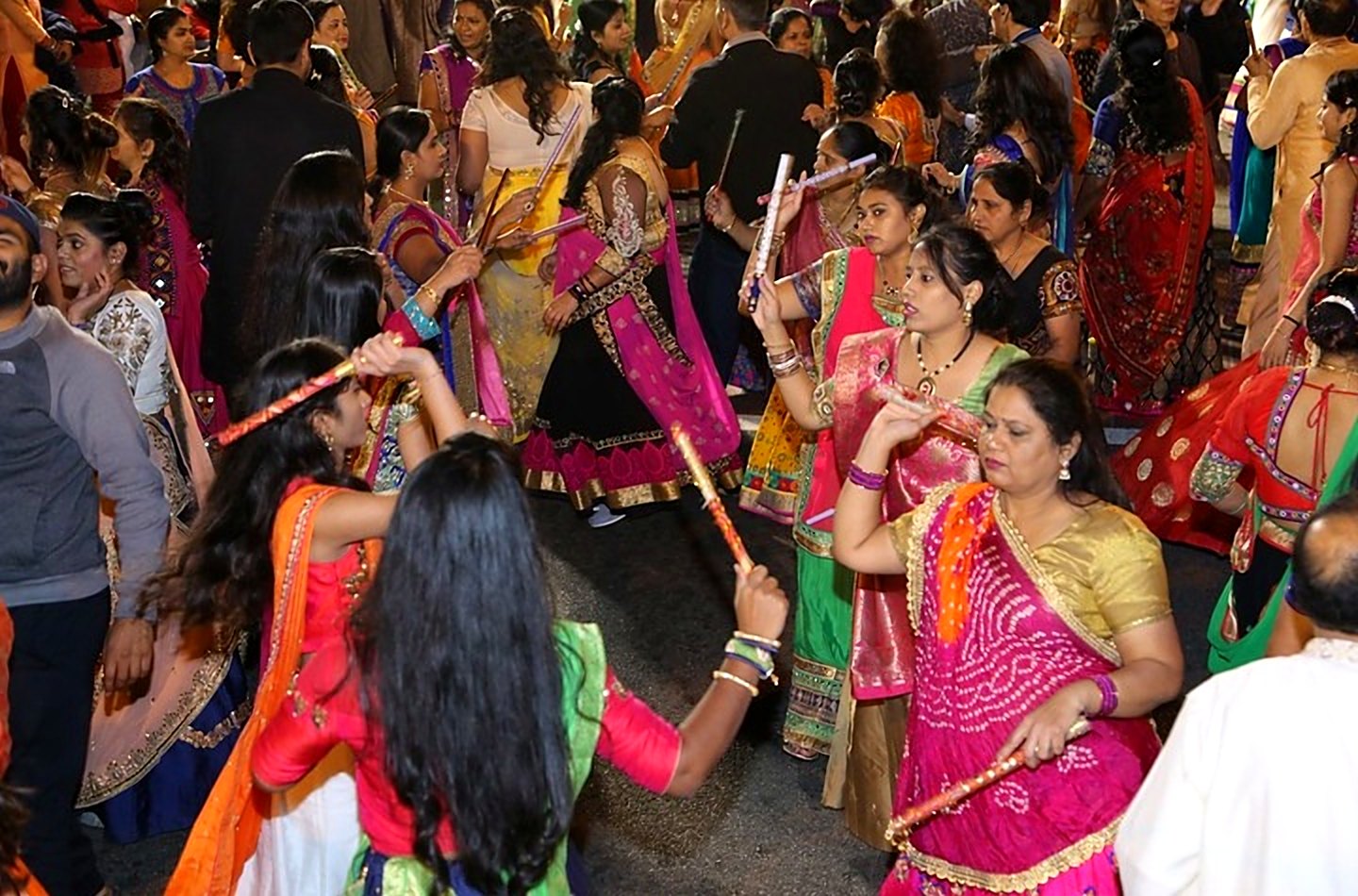 Women in chaniya choli playing dandiya on Newark Avenue